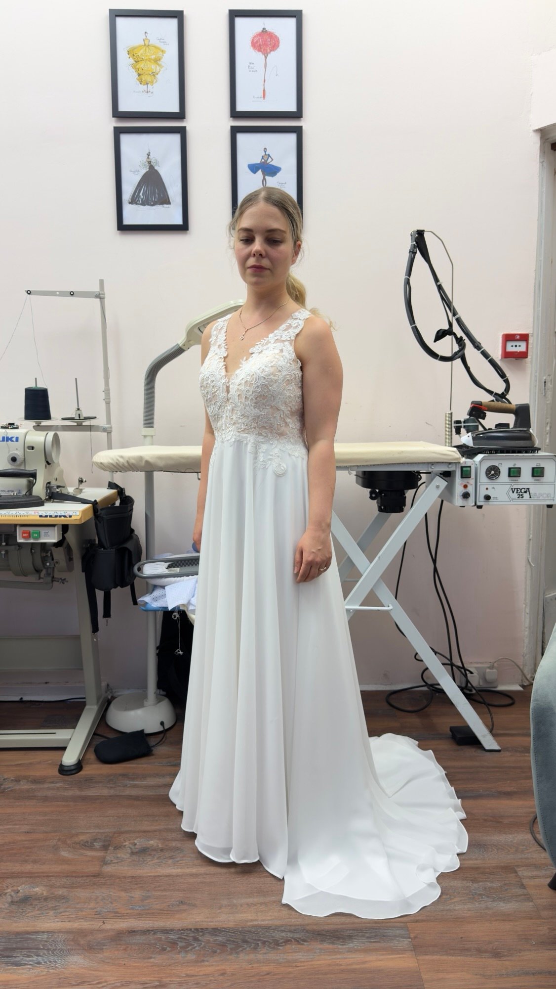 Front bridal gown fitting with lace bodice and flowing train